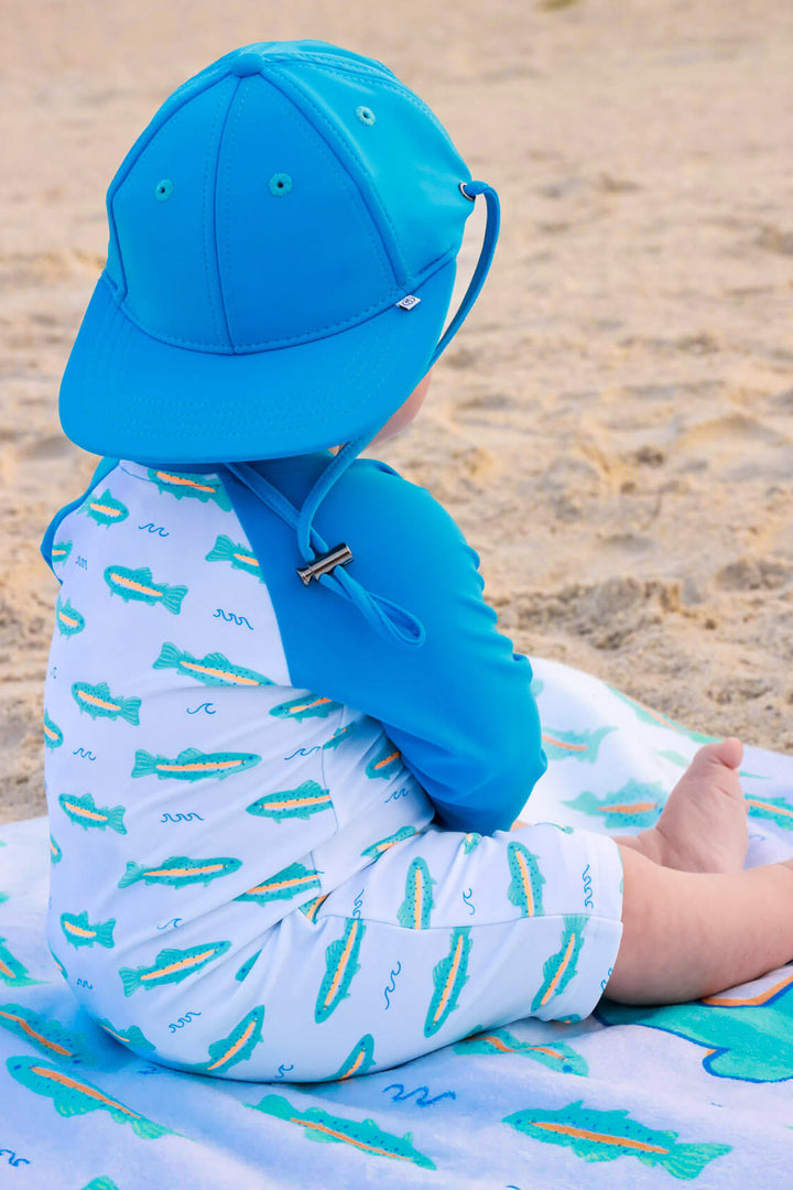 back view of tiny trout swim romper with matching twilight tide surf hat 