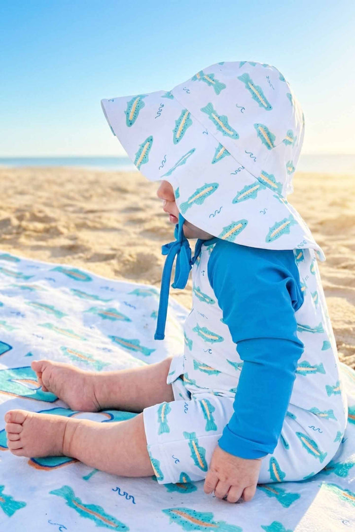 side view of tiny trout swim romper and hat for babies 