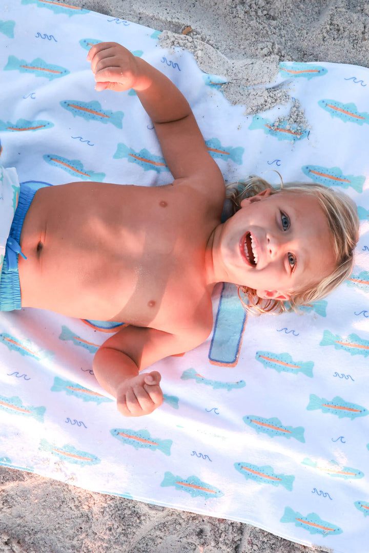 boy laying on trout personalized beach towel 