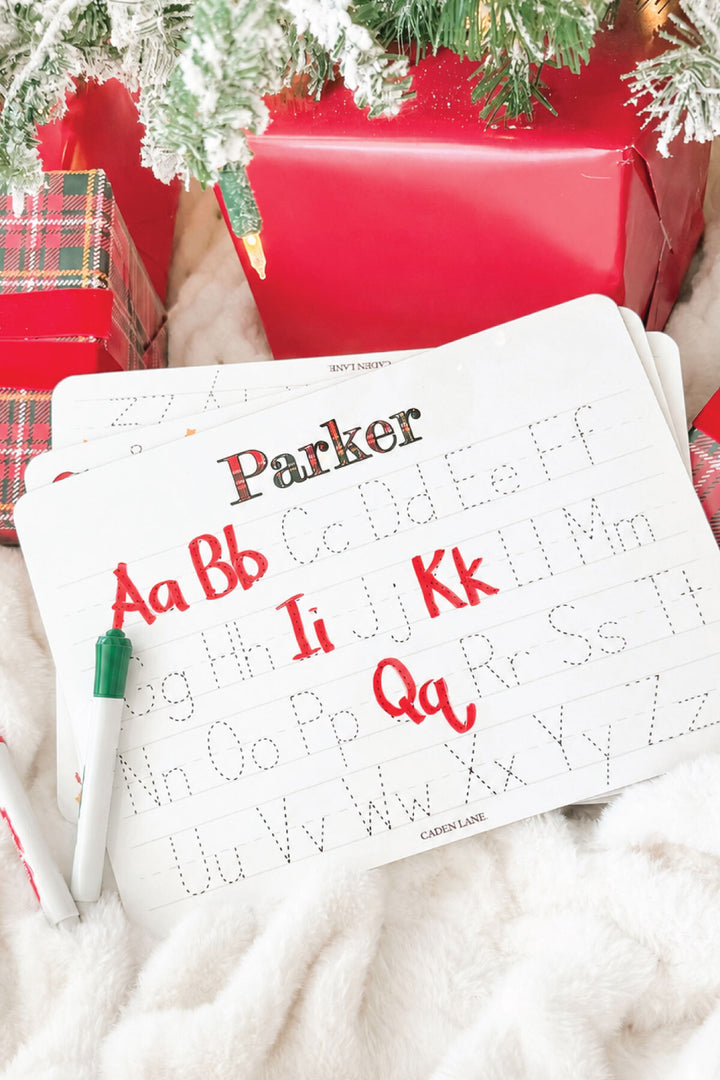 Caden Lane personalized Christmas handwriting practice board featuring the name "Parker" in festive red and green plaid lettering with traceable uppercase and lowercase alphabet, creating a fun personalized holiday learning gift for kids.