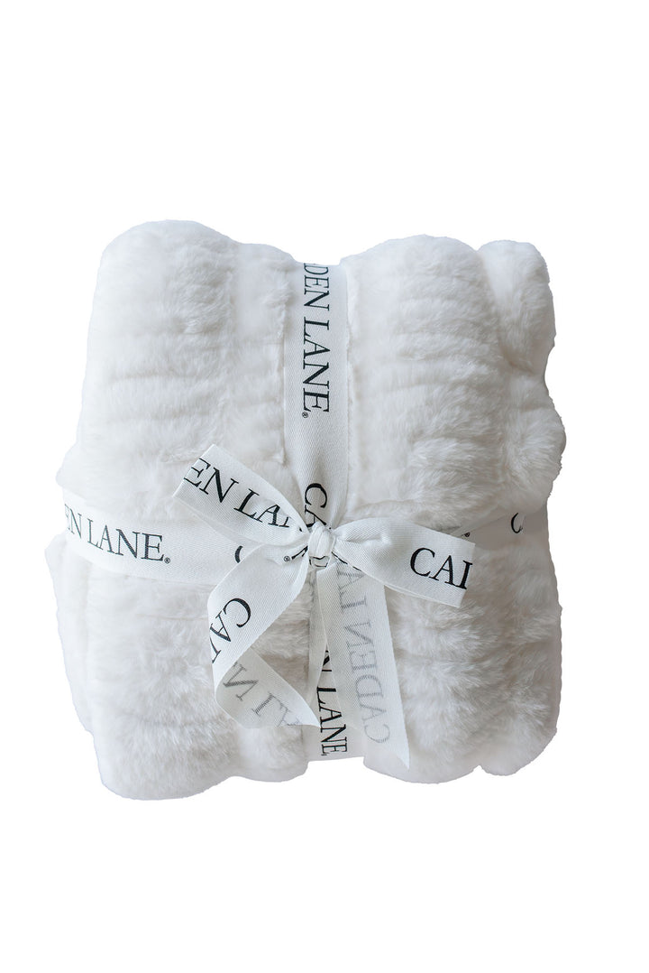 Folded double-ruched faux fur baby blanket in winter white, tied with a Caden Lane ribbon