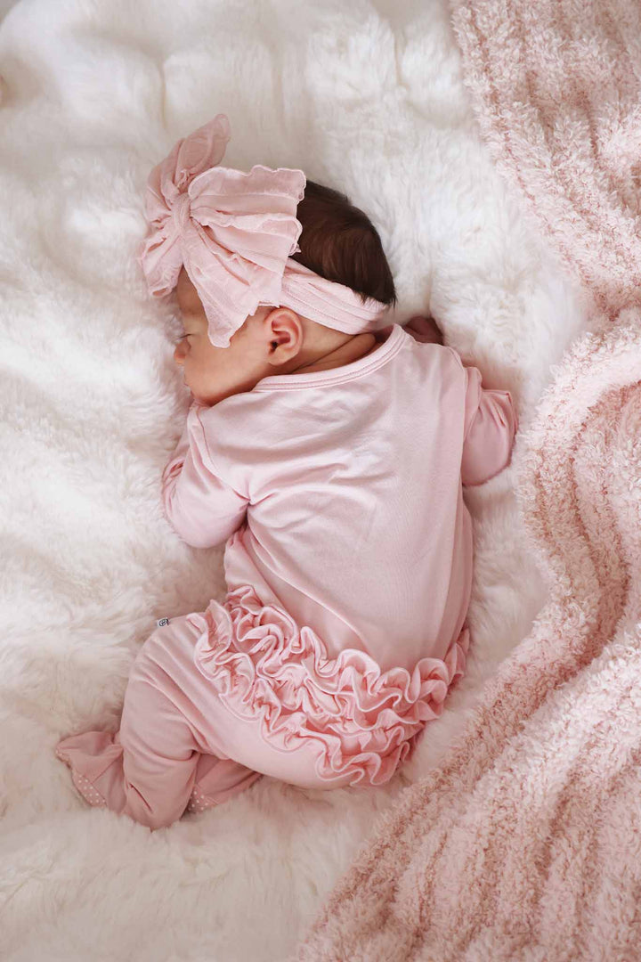 view of back of light pink ruffle bottom zipper footie for baby girls 