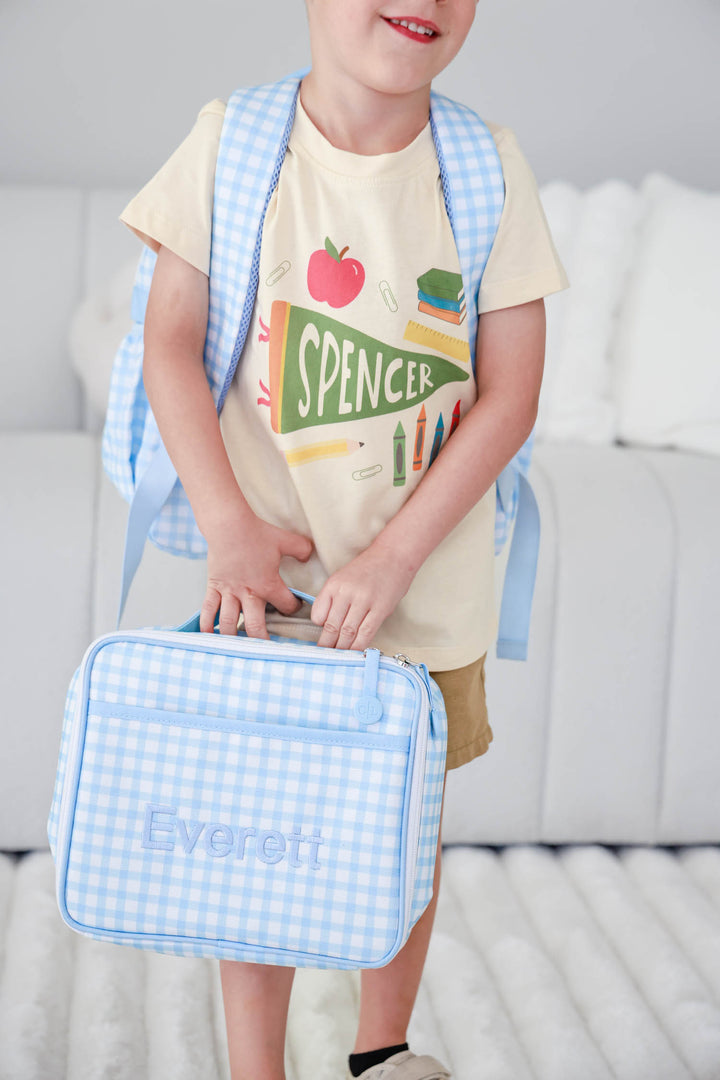 boy holding back to school blue gingham embroidered lunchbox and backpack with personalized t-shirt