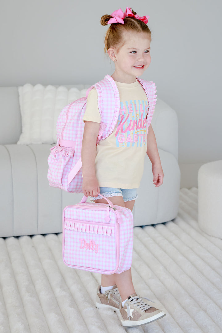 girl holding embroidered pink gingham lunchbox with matching backpack 