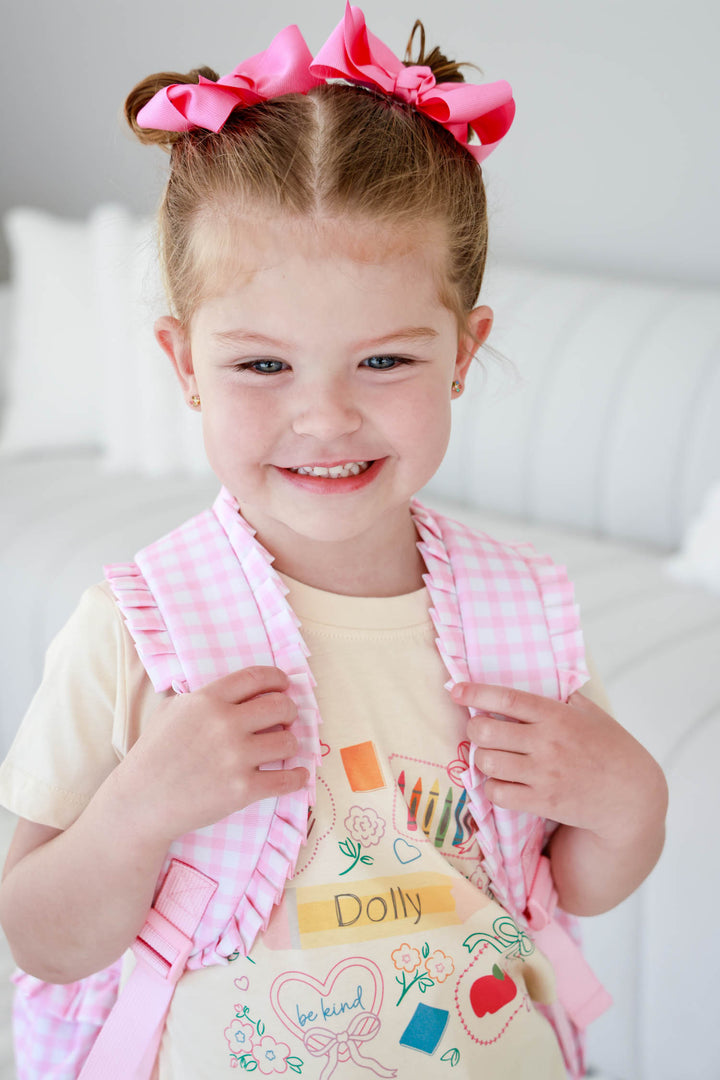 girl holding pink gingham backpack wearing a girly back to school tee