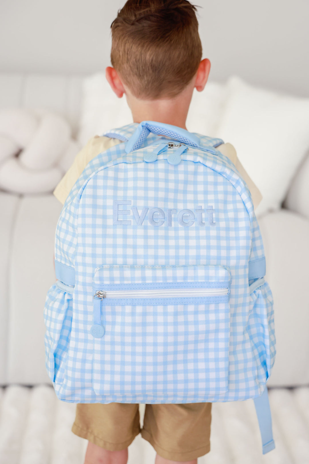 boy wearing blue gingham embroidered backpack