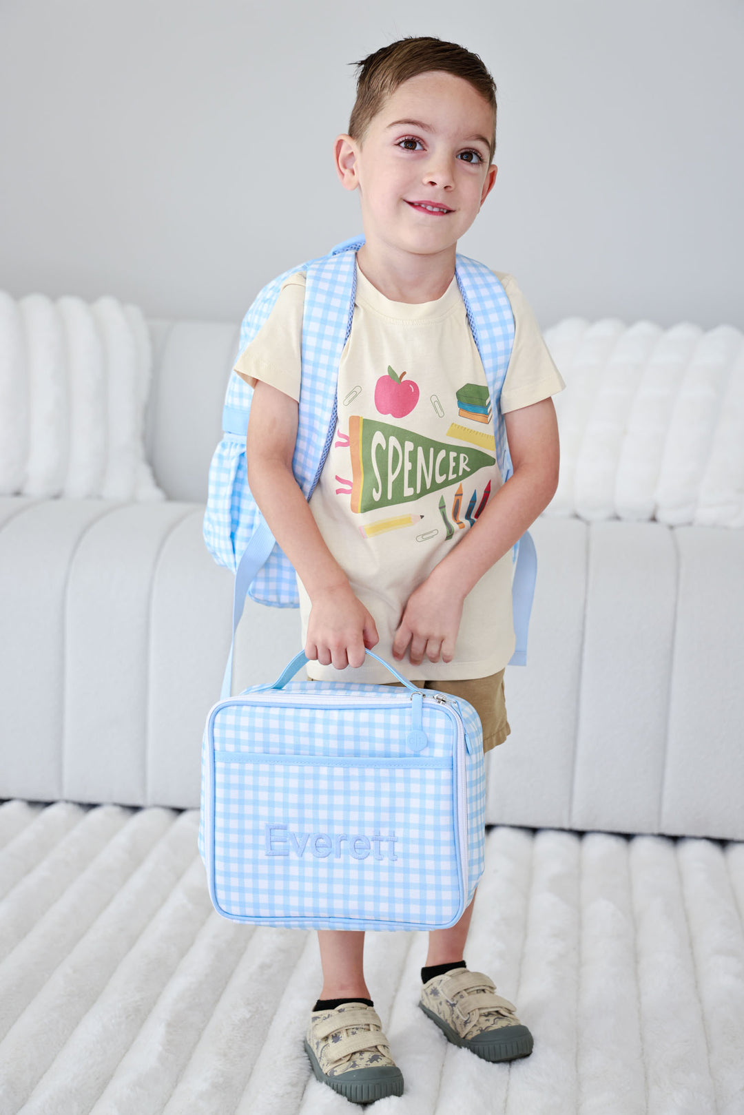 boy wearing back to school personalized tee with a blue gingham embroidered lunchbox and backpack