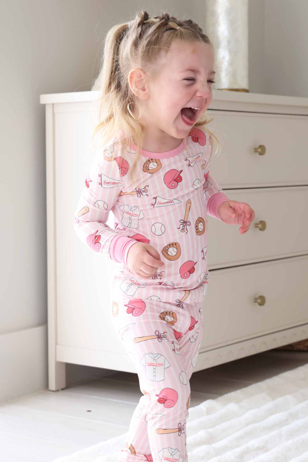 laughing girl in long sleeve ballpark babes two piece pajama set pink
