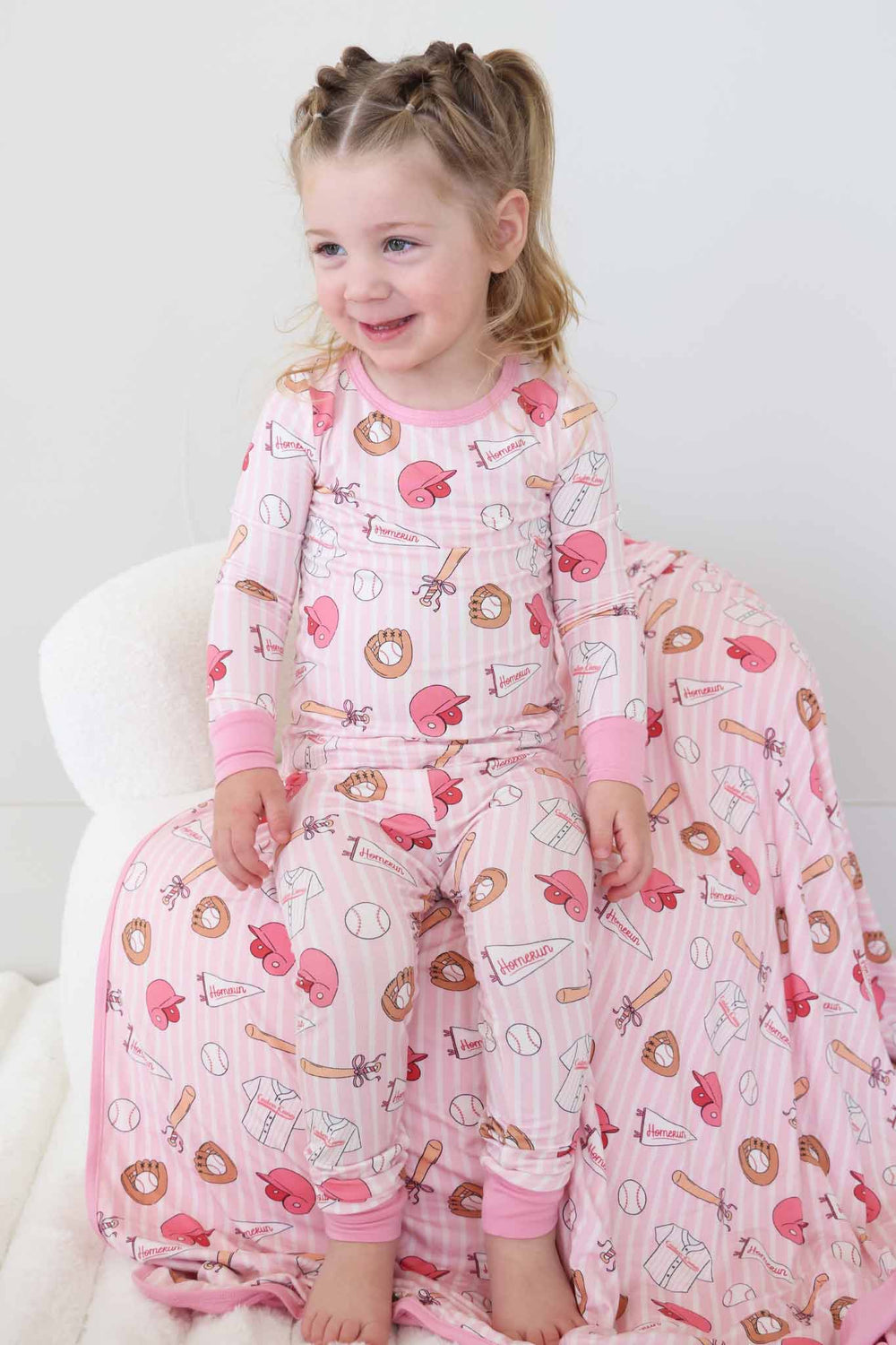 girl sitting on chair in pink ballpark babes girly baseball two piece pajama set 