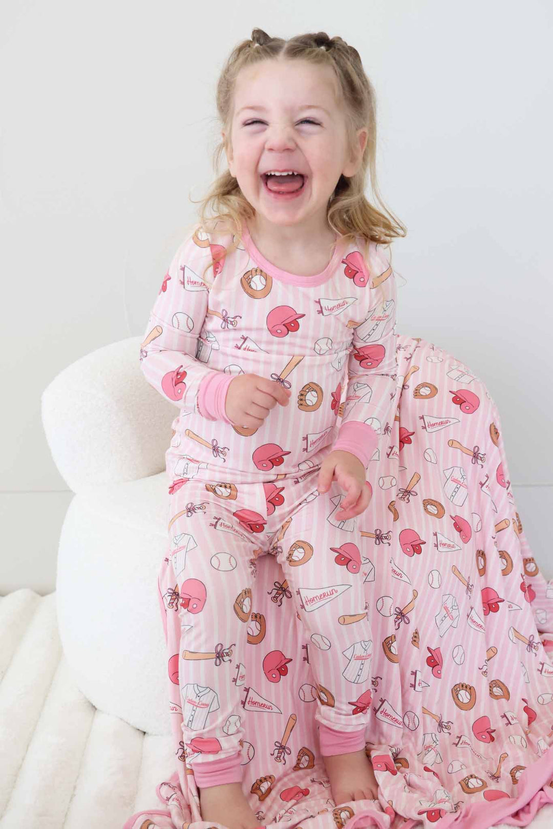 laughing girl in pink stripes girly baseball themed two piece bamboo pajama set 