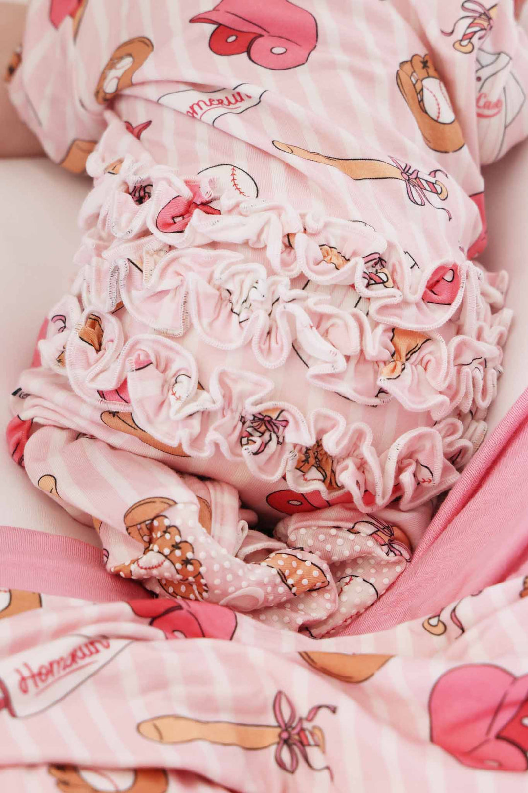 back view of ruffle bottom zipper footie for girls in pink ballpark babes print 