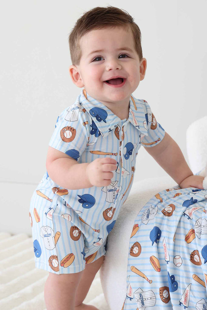 ballpark bros collared button romper for boys with matching blanket draped over ottoman