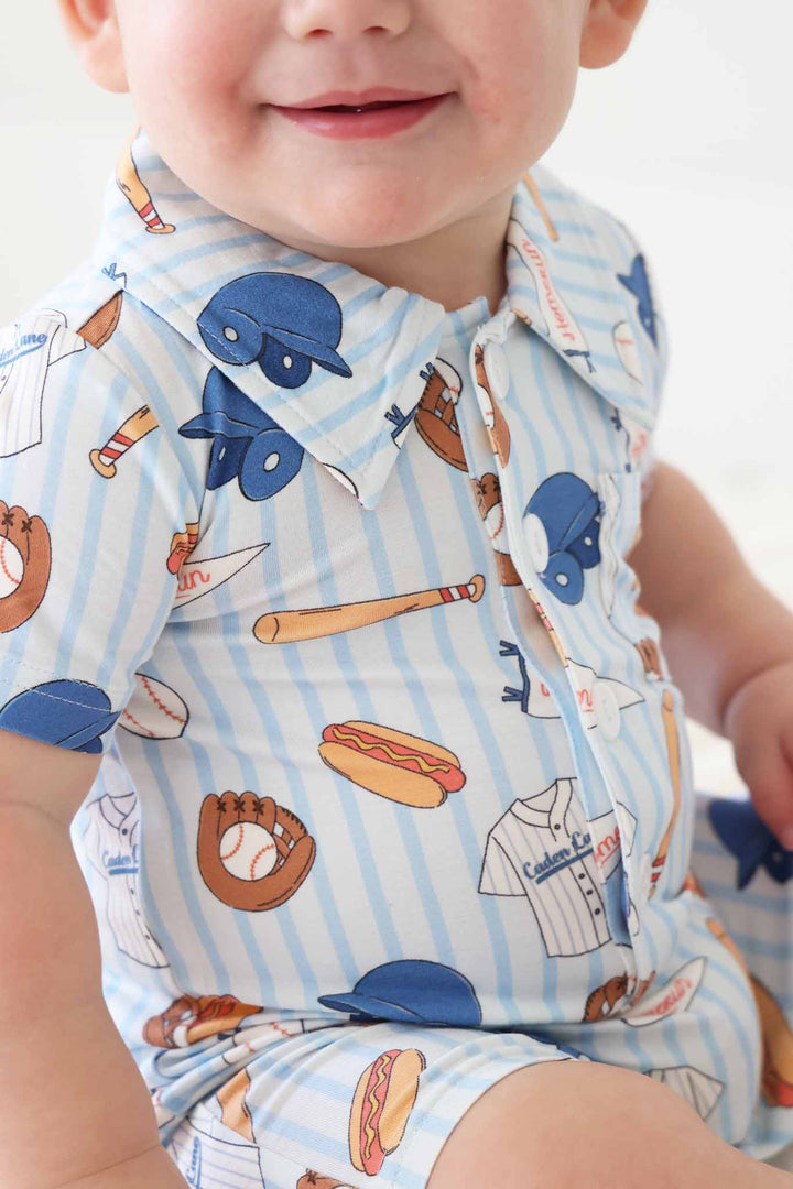 closeup of collared button romper for boys in blue striped baseball print with bats, hotdogs, helmets, jerseys and more 