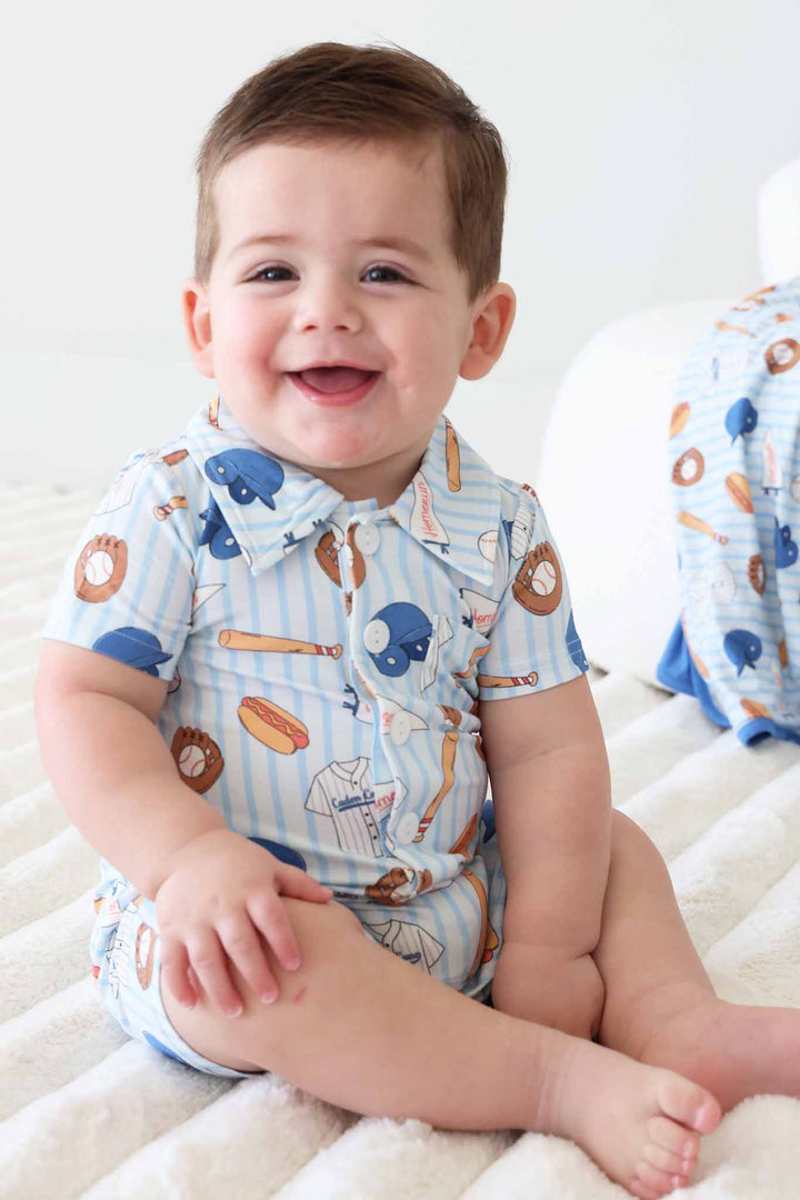 smiling baby boy in baseball themed daytime romper outfit