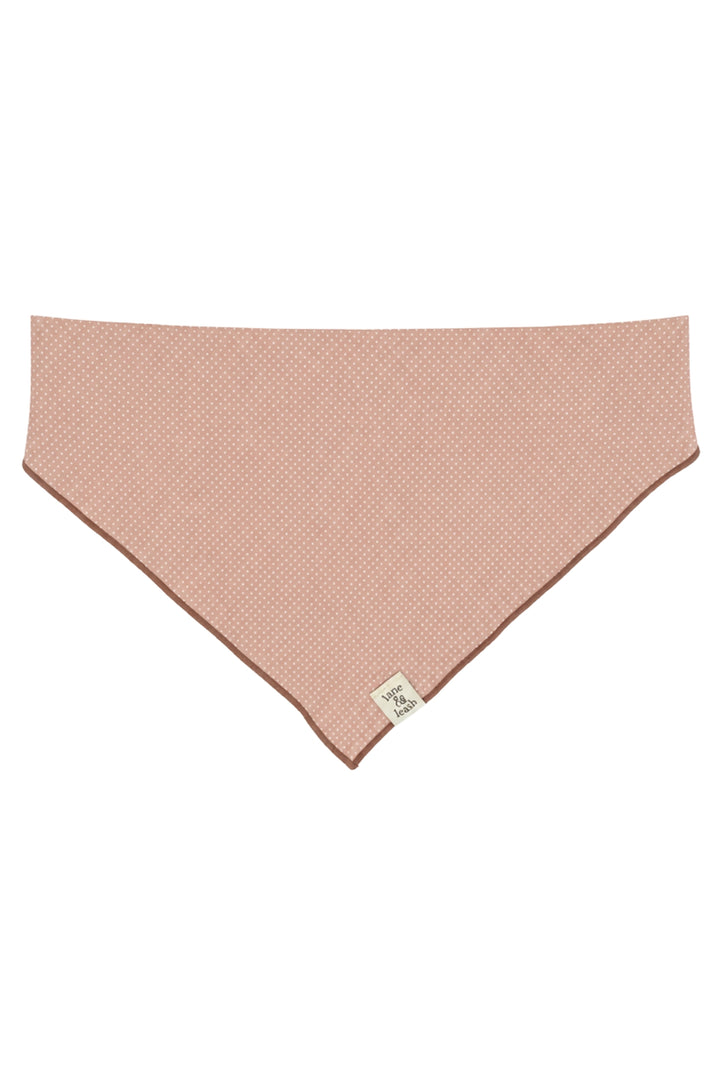 Flat lay of latte pink polka dot pet bandana in a triangle shape on a white background