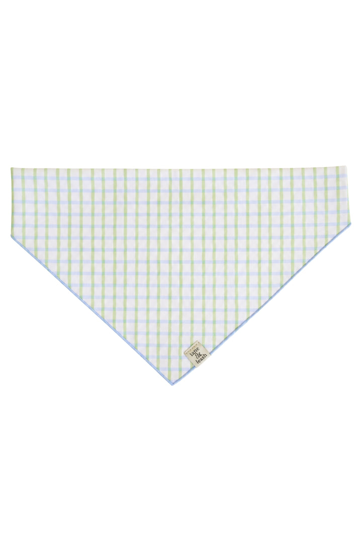 Flat lay of an embroidered pet bandana in green and blue picnic plaid, shown as a triangle with a Caden Lane label tag at the bottom tip