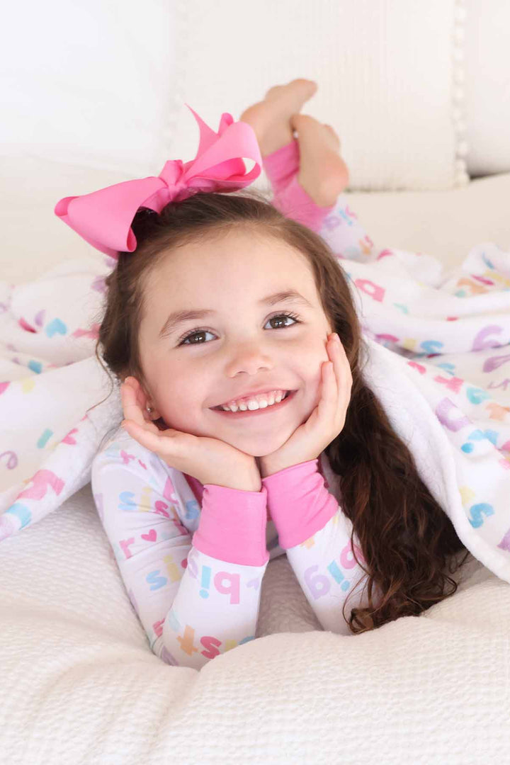 girl with matching big sister personalized kids blanket and pajamas