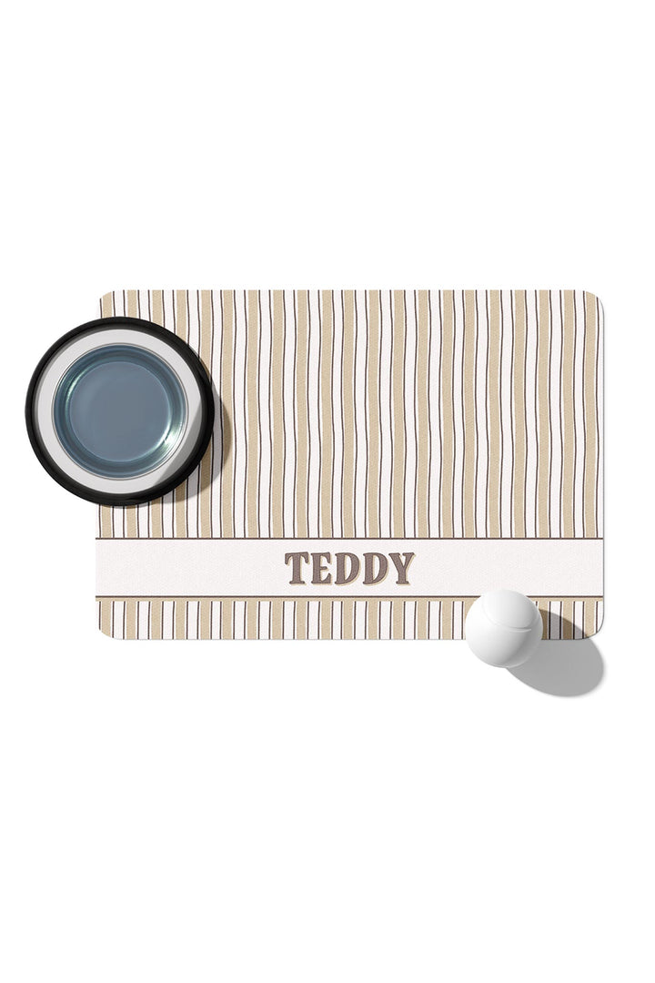 Personalized pet placemat in Biscuit Stripe pattern with a pet food bowl resting on it and the name TEDDY printed on the white border at the bottom