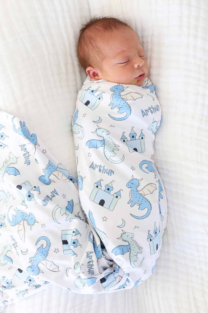 newborn boy wrapped in dragon and castle swaddle blanket personalized with name 