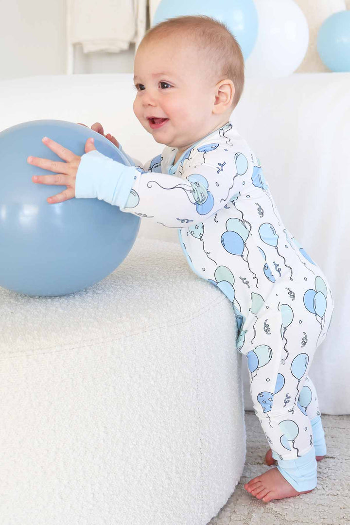 standing baby boy wearing blue party time convertible zip romper 