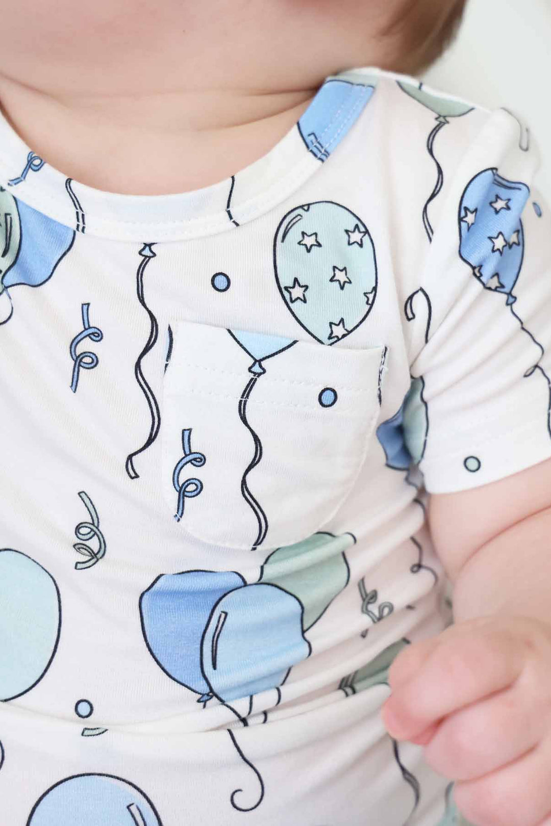 short sleeve graphic tee for babies with light blue and green balloon with a front pocket 
