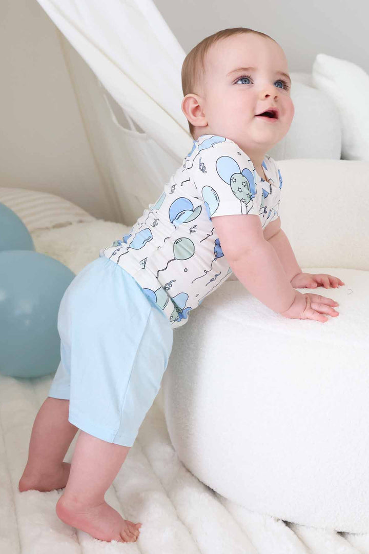 bow leaning on ottoman wearing a short sleeve balloon shirt with matching light blue shorts 