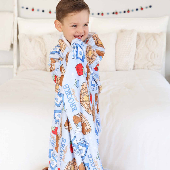 boy wrapped in breakfast themed personalized kids blanket 