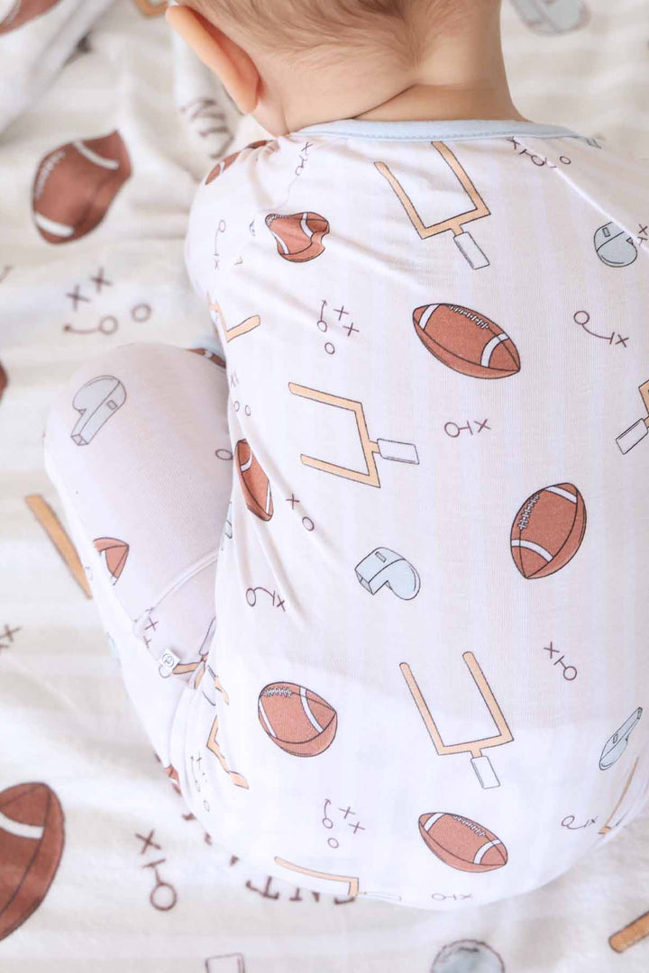 blue football pajama romper for baby boys with neutral stripes 
