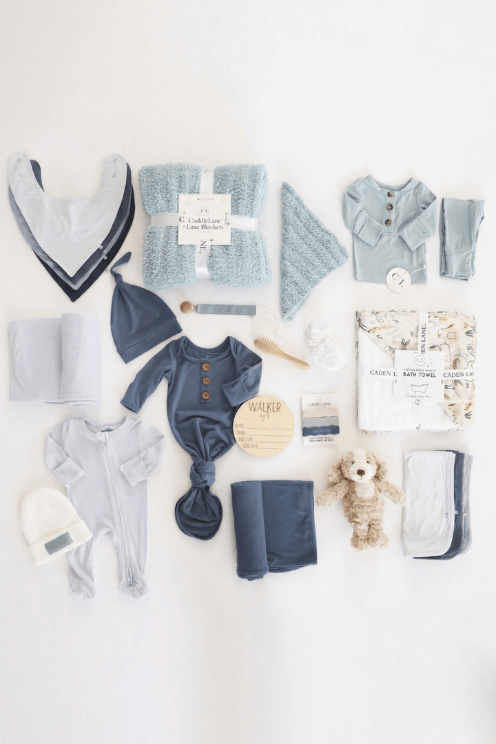 deluxe baby shower gift box bundle for boys with blue 2pc waffle, zipper footie, knot gown, wood  stats, swaddles, bottle labels, burps, socks, paci clip, beanie, lovey, blanket, hooded towel, hair brush, dog stuffed animal