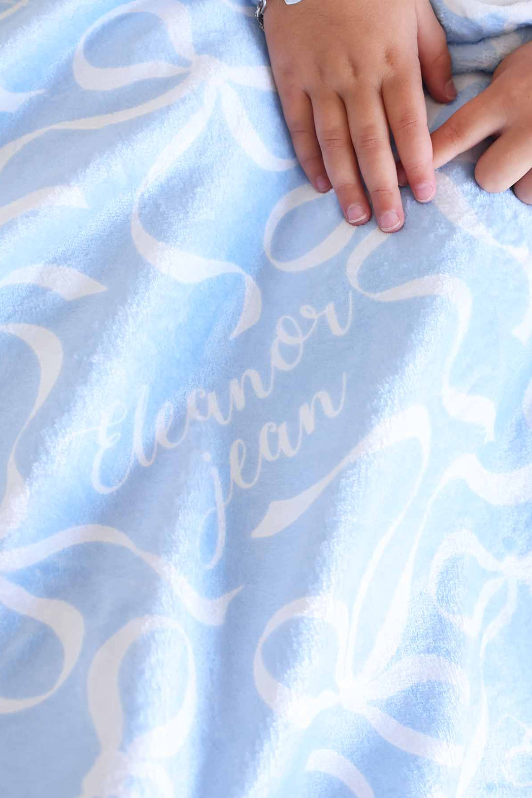light blue personalized kids blanket with white bows 
