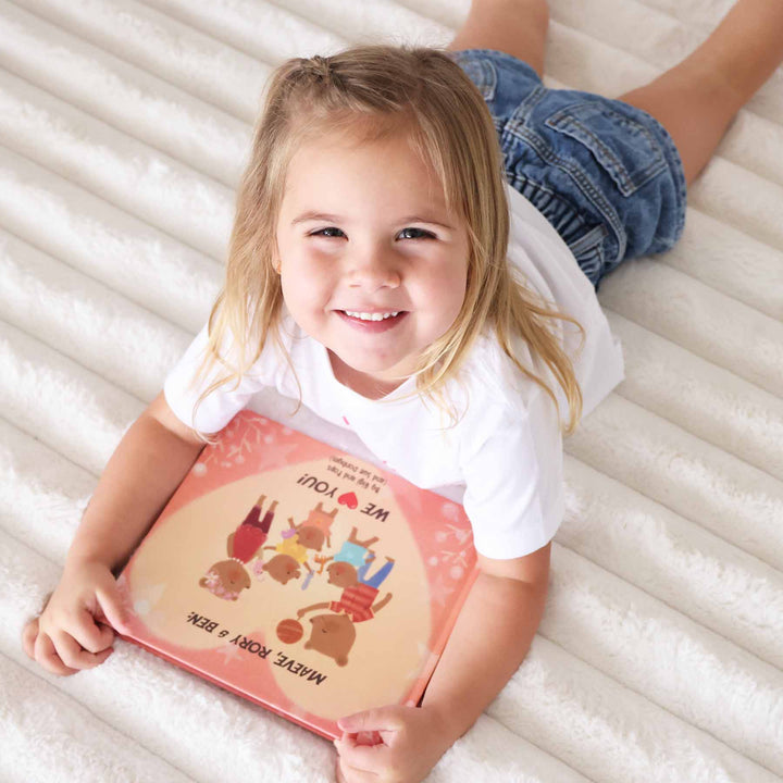 girl with personalized kids books from grandparents