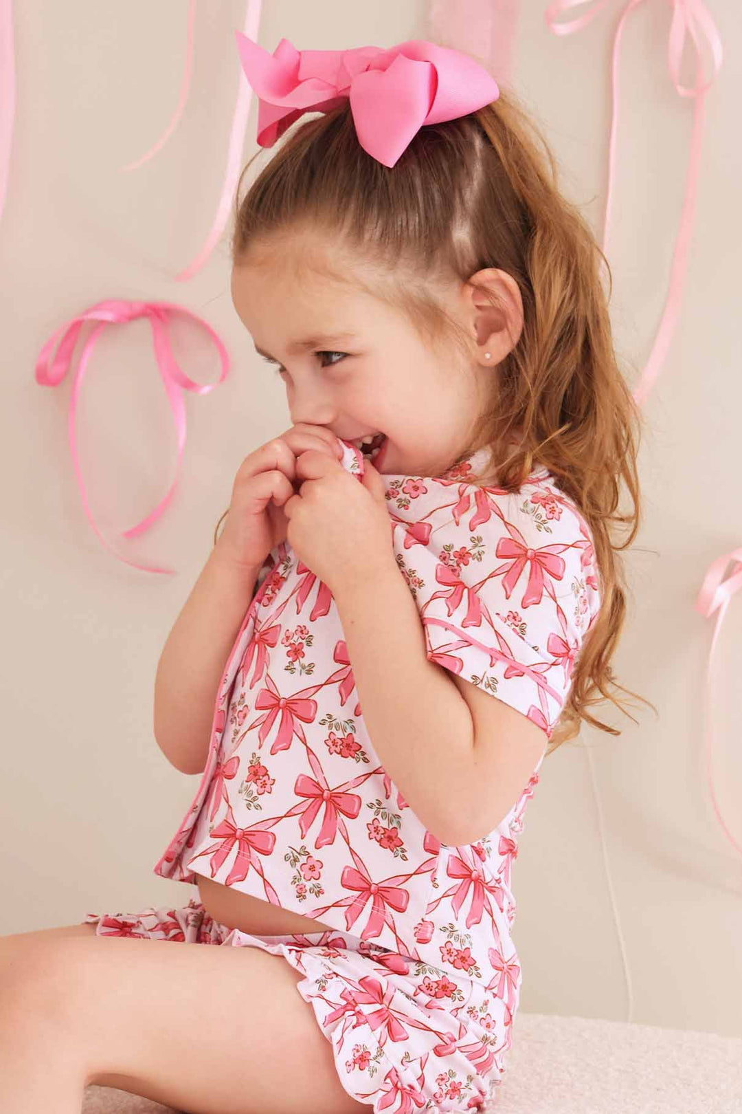 kid in short sleeve matching pajama set with bows and flowers