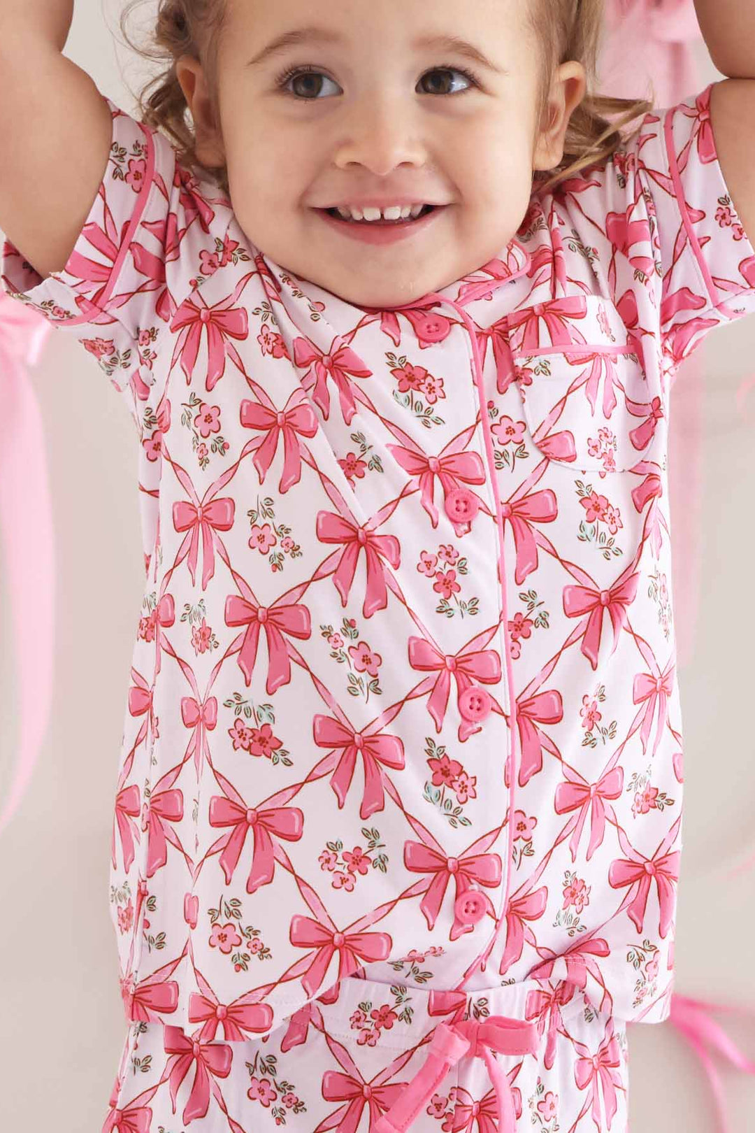 girl in short sleeve matching pajama set with bows and flowers