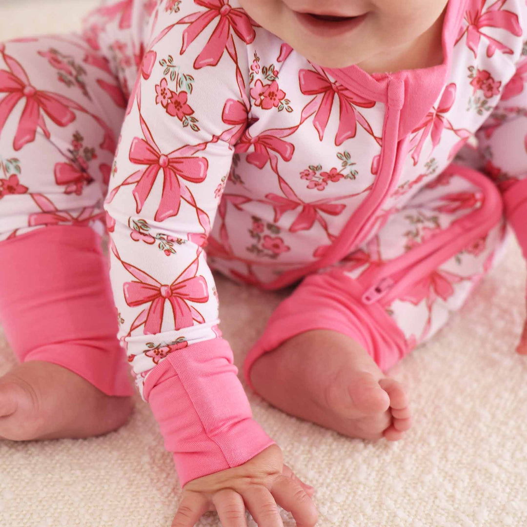 zip romper pajamas with pink trim and bow print for babies