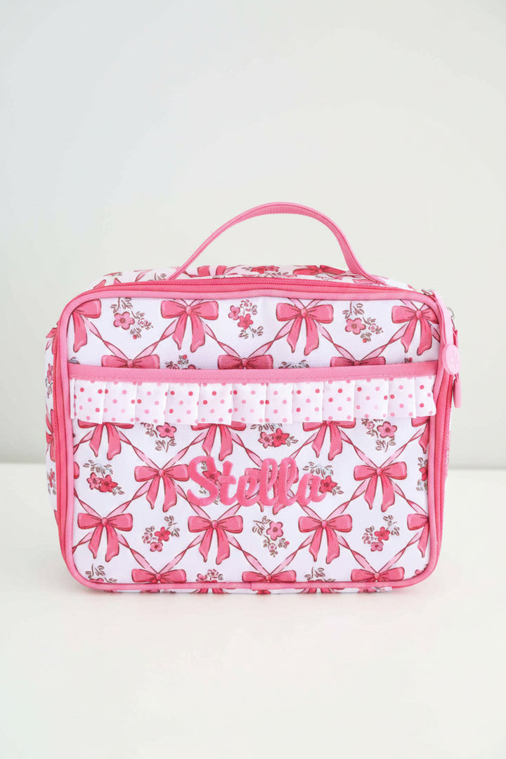 hot pink bow lunchbox embroidered with name with polka dot trim and front pocket 