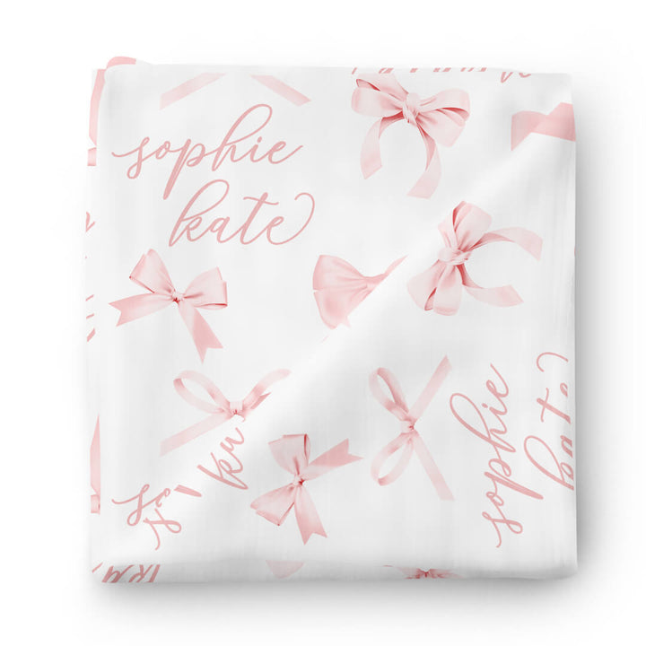 white personalized swaddle for babies with pink bows 