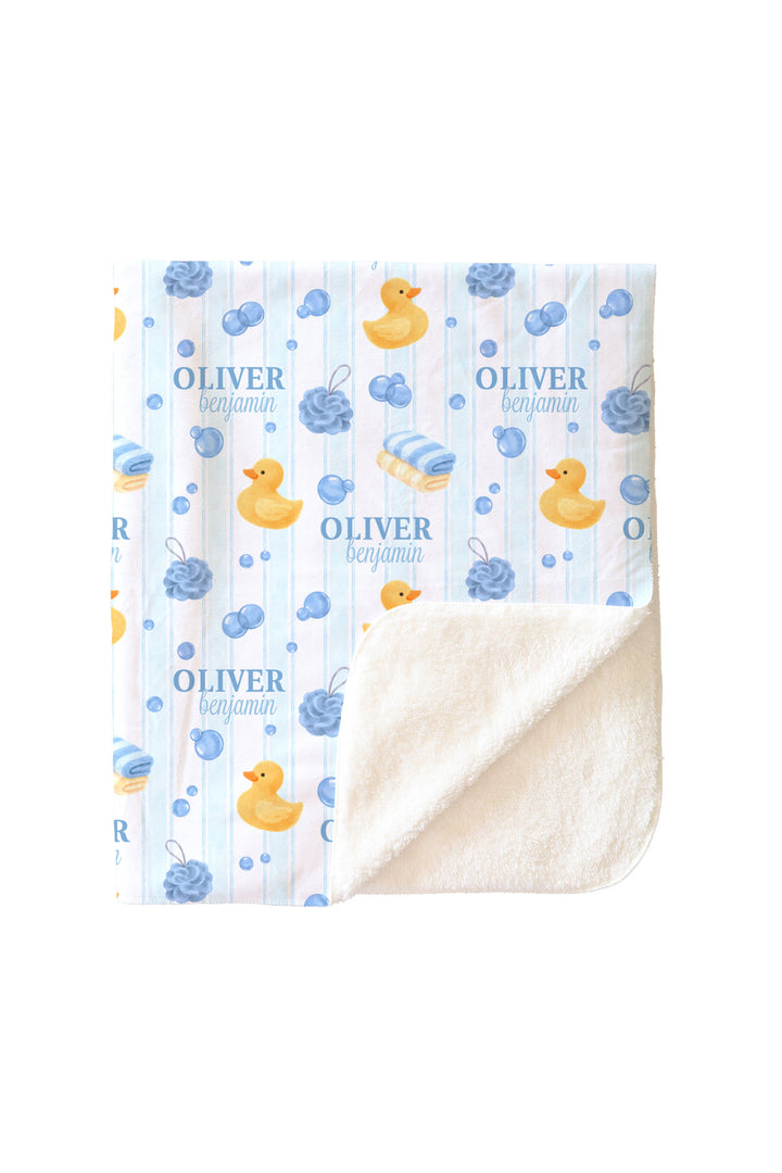 Boy cuddling in blue Bubble Duckies personalized sherpa blanket with yellow rubber duck and blue bubble print