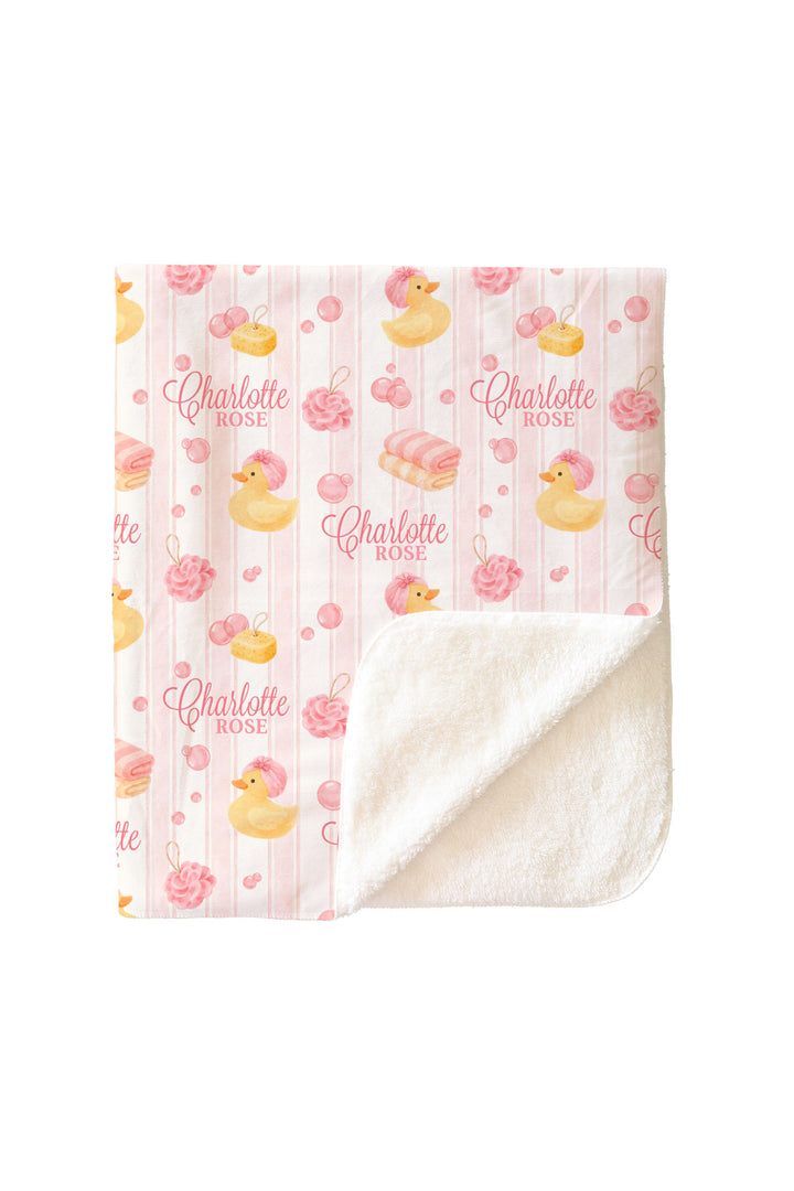 Child holding pink Bubble Duckies personalized sherpa blanket with yellow rubber duck and pink rose print