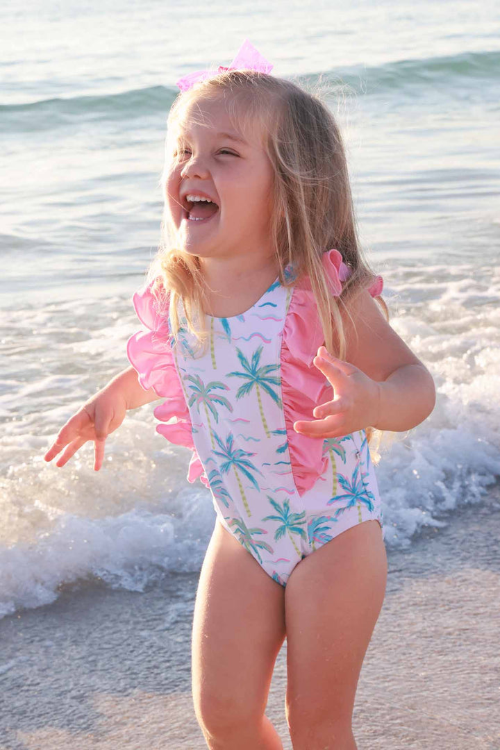 girl at the beach in neon palm tree double ruffle one piece 