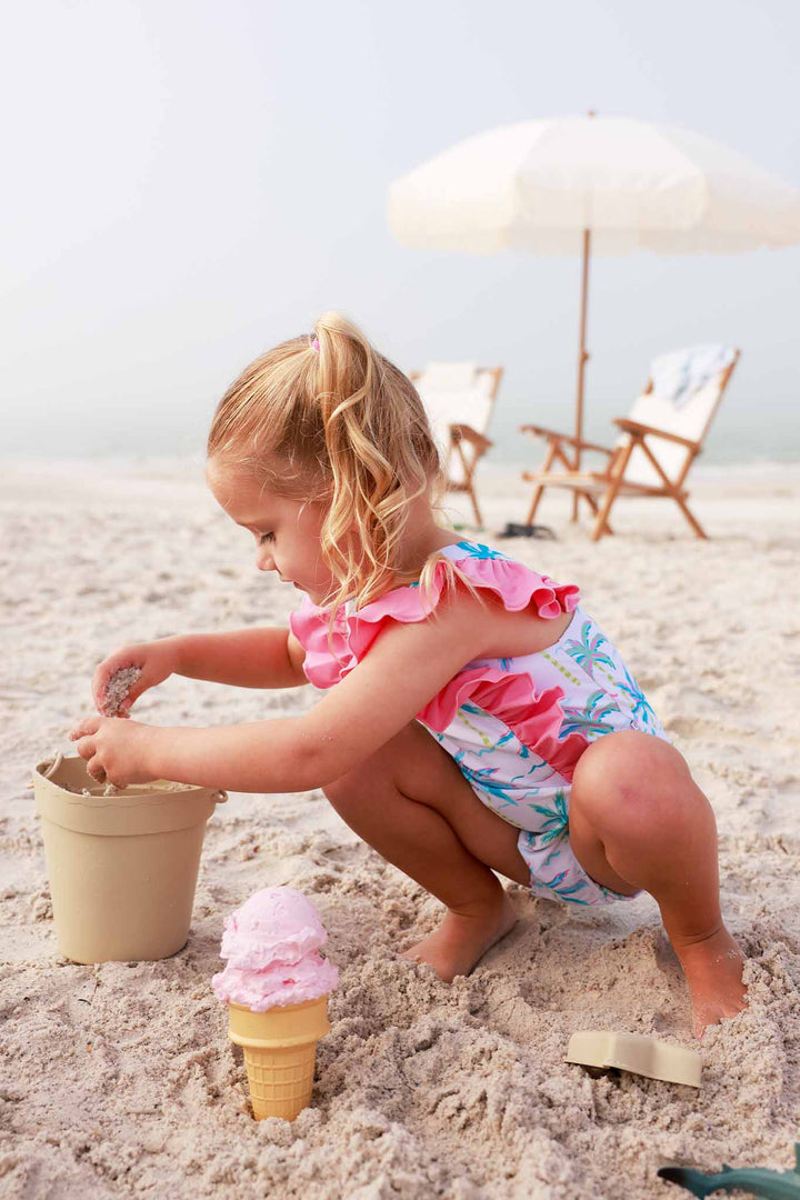 girl playing in the sand at the beach in blue lagoon double ruffle one piece 