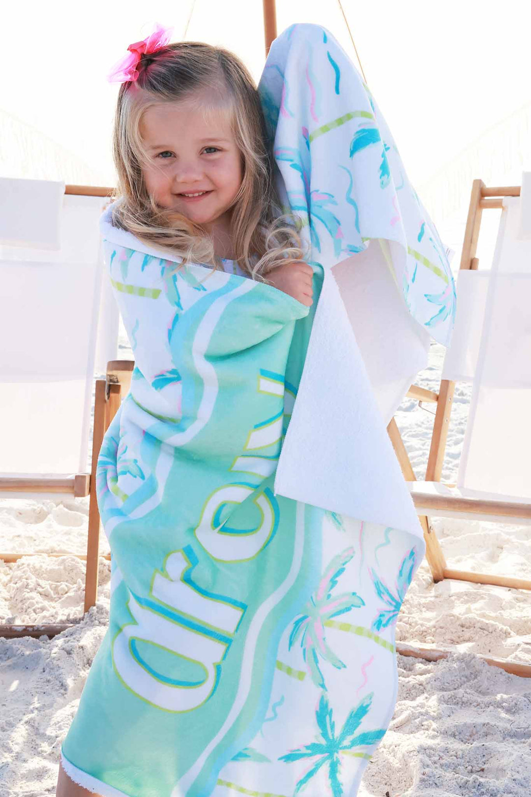 girl on beach wrapped up in personalized beach towel 