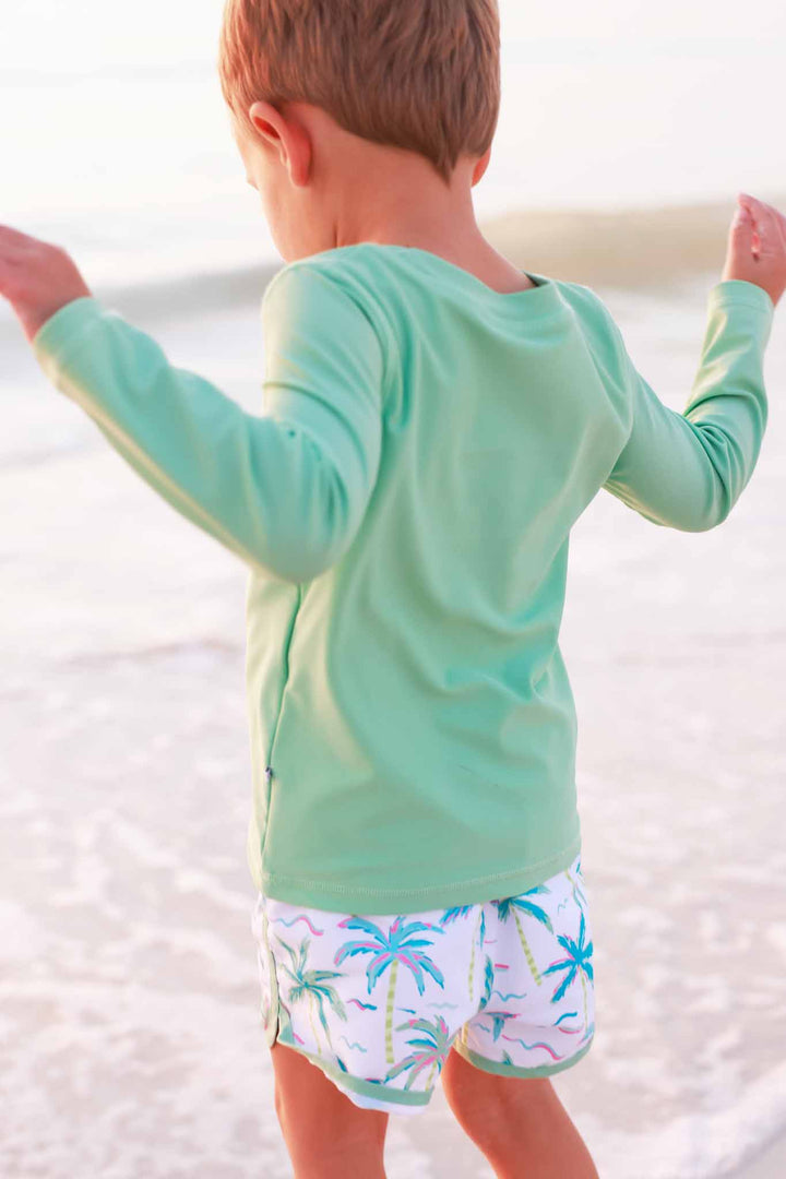 bright green long sleeve rash guard shirt for boys with matching palm tree swim trunks 