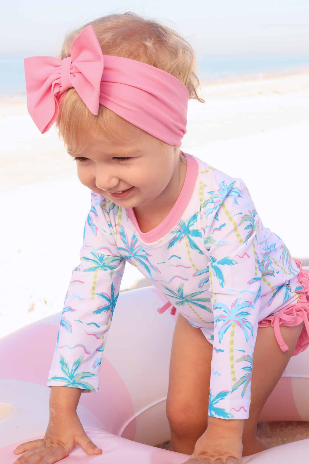 blue lagoon palm tree rash guard swimsuit with a matching pink swim bow