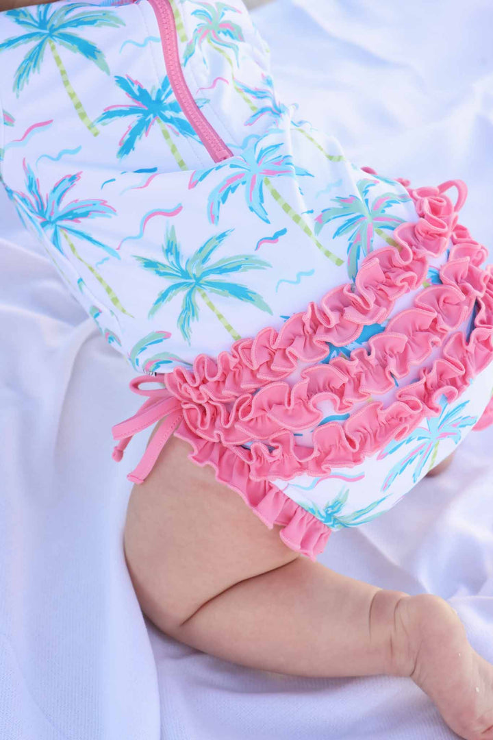 neon pink palm tree rash guard with pink ruffles on the bottom 