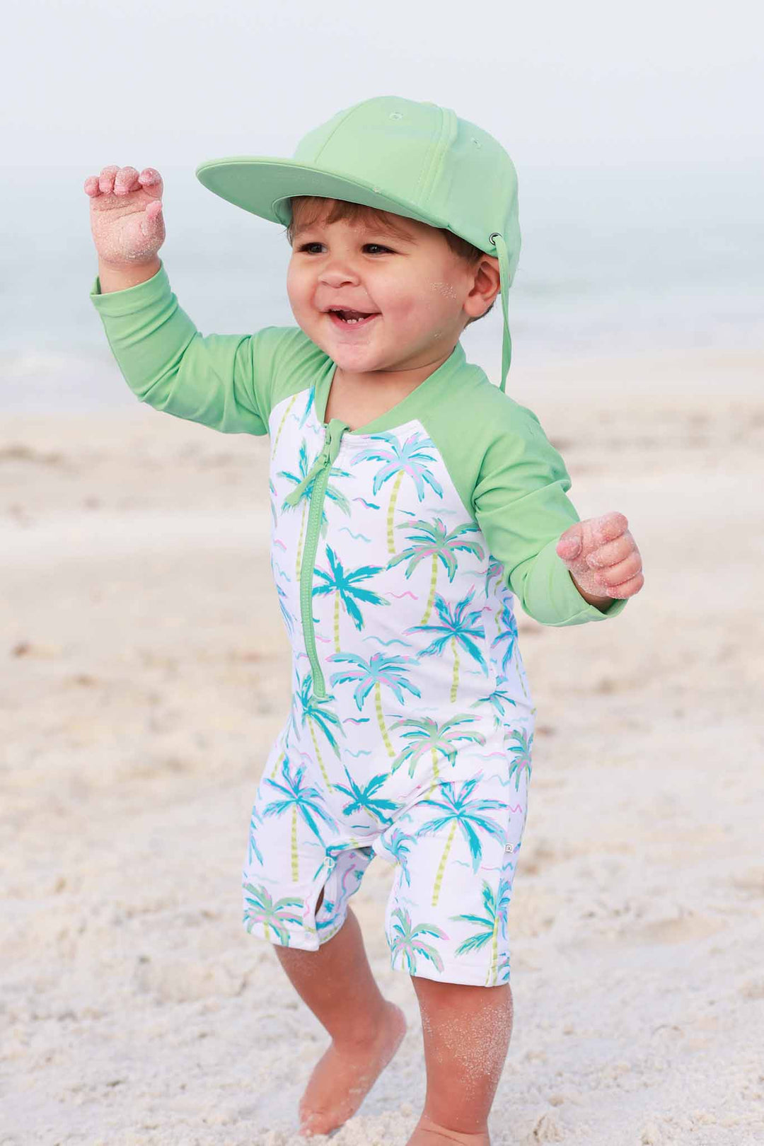 blue lagoon shortie romper with long sleeves and matching neon green surf hat 
