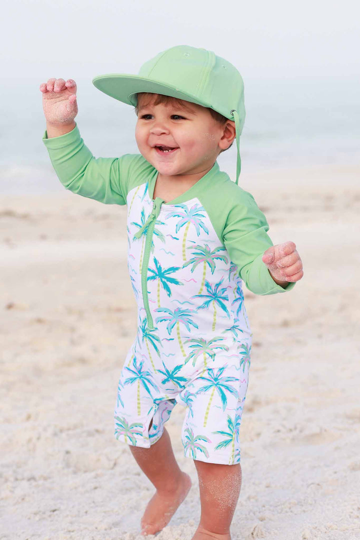 blue lagoon shortie romper with long sleeves and matching neon green surf hat 