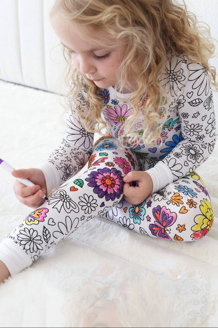 Little Girl wearing the Colorable Two Piece Pajama Set | Floral Flutter while coloring it in