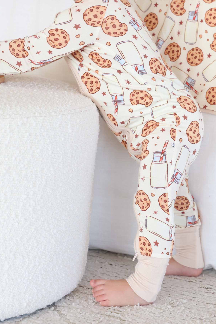 Side profile of baby standing while wearing the Cookie Cuddles Convertible Zip Romper