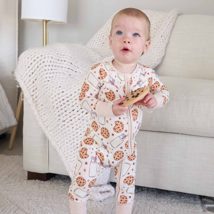 Baby standing with cookie toy wearing Cookie Cuddles Convertible Zip Romper