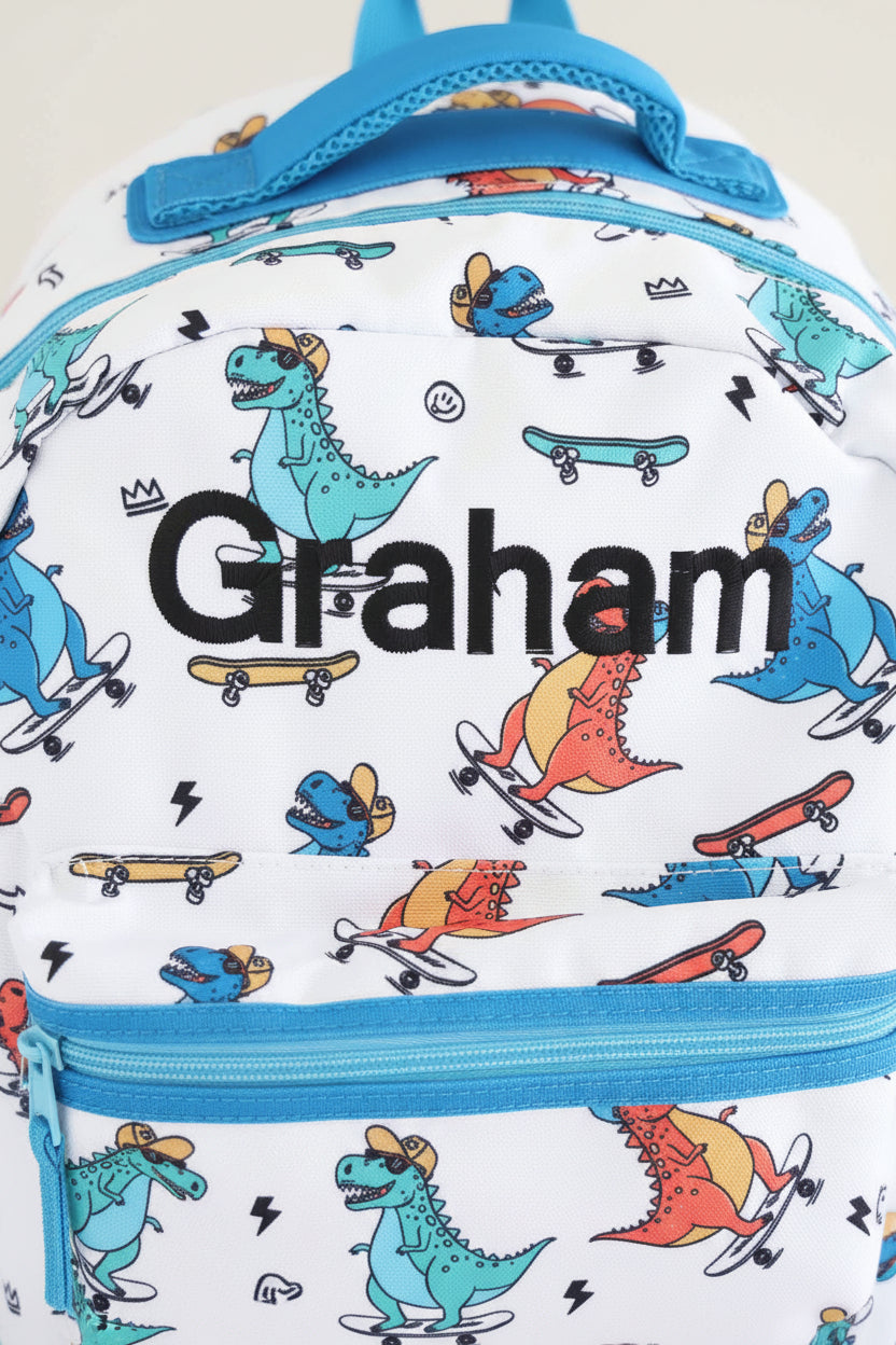 black thread embroidered name backpack for boys with skateboarding dinosaurs 
